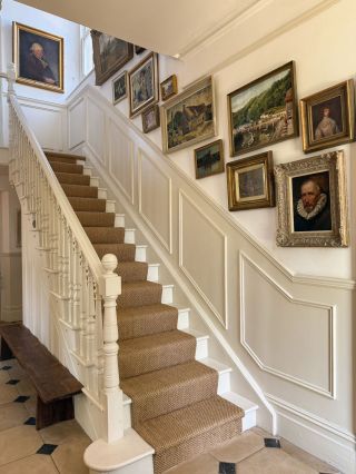 sisal stair runner carpet on cream wooden stairs in English country house